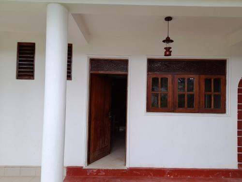 an open door of a white building with at Polhena Palms in Polhena