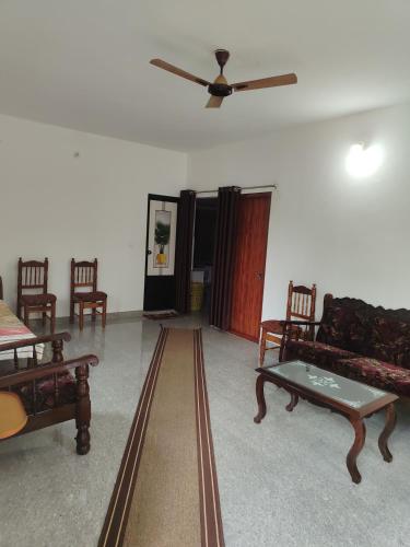 a living room with furniture and a ceiling fan at Shivalaya Homestay, Madikeri in Siddapur