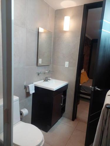 a bathroom with a white toilet and a sink at Departamento en Cholula Pue La Concordia C4 in Acatepec