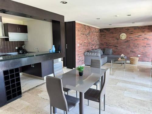a kitchen and living room with a table and a couch at Departamento en Cholula Pue La Concordia C4 in Acatepec