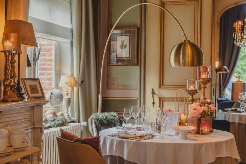 a dining room with a table with wine glasses at Charmehotel Manoir Ogygia in Poperinge