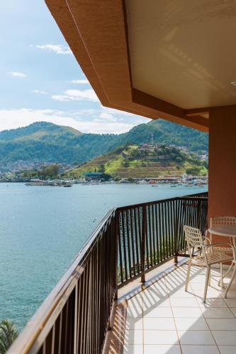 a balcony with chairs and a view of the water at Hotel Nacional Inn Angra dos Reis in Angra dos Reis