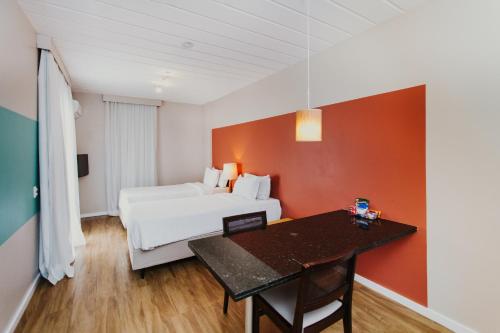 a hotel room with a bed and a dining table at Hotel Nacional Inn Angra dos Reis in Angra dos Reis