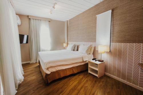 a hotel room with a bed and a window at Hotel Nacional Inn Angra dos Reis in Angra dos Reis