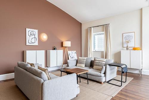 a living room with two couches and a table at Bright and Stylish Riverside Haven in Canary Wharf in London