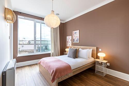 a bedroom with a bed and a large window at Bright and Stylish Riverside Haven in Canary Wharf in London
