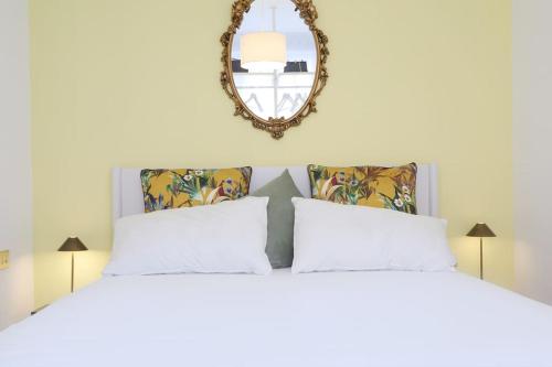 a bedroom with a large white bed with a mirror at La casa di Visi in Milan