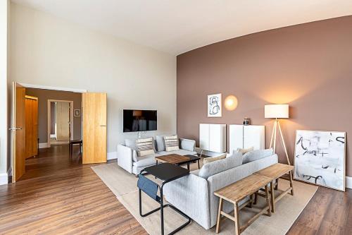 a living room with a couch and a table at Bright and Stylish Riverside Haven in Canary Wharf in London