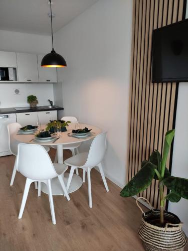 a dining room with a white table and chairs at Sauna, Pools mit XXL-Terasse oder Kinderkino in Sankt Englmar