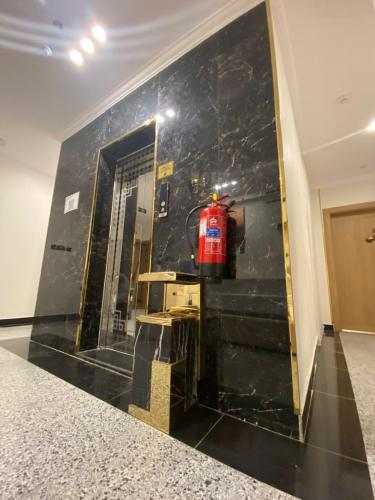 a black marble wall in a room with a fire extinguisher at Orchid Hotel Madinah in Al Madinah