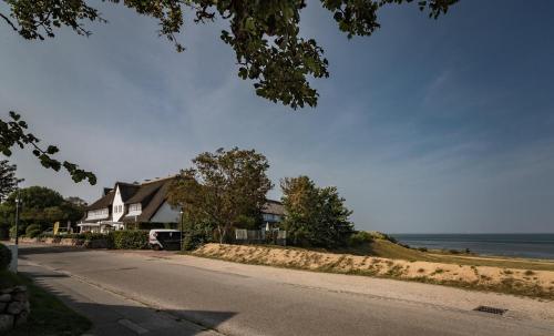 a house on the side of a road next to the ocean at Alte Mühle direkt am Wattenmeer in Keitum