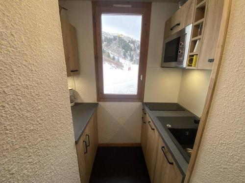 une petite cuisine avec une fenêtre et un évier dans l'établissement Appartement au pied des pistes avec balcon et casier à ski, non-fumeur - FR-1-355-117, à Méribel