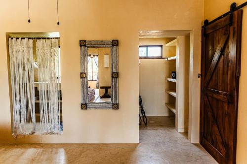 Cette chambre comprend une porte et un miroir mural. dans l'établissement 3 Bedrooms house shared pool, à Holbox
