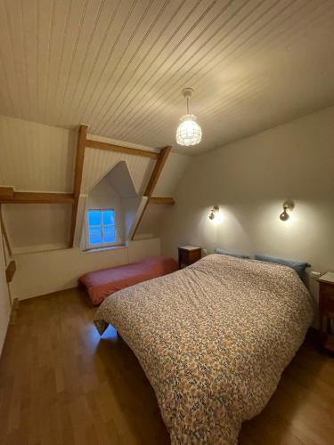 une chambre avec un lit dans un grenier dans l'établissement Grande maison vue mer exceptionnelle, à Vauville