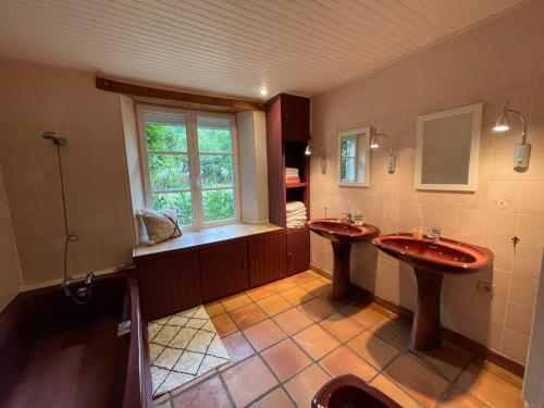baño grande con 2 lavabos y ventana en Grande maison vue mer exceptionnelle, en Vauville