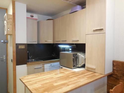 une cuisine avec un comptoir avec un micro-ondes dans l'établissement Studio divisible 4 pers, animaux admis, centre station La Plagne - FR-1-353-90, à La Plagne Tarentaise