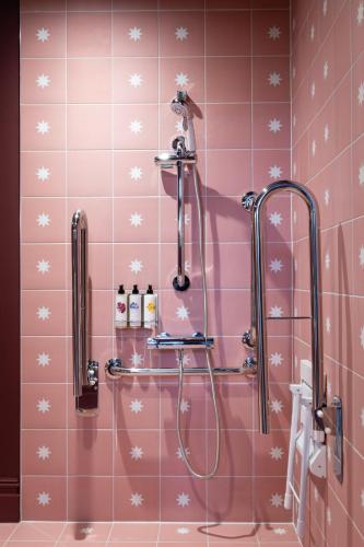 a bathroom with a shower with pink tiled walls at The Royal Forest - A Heartwood Inn in Chingford
