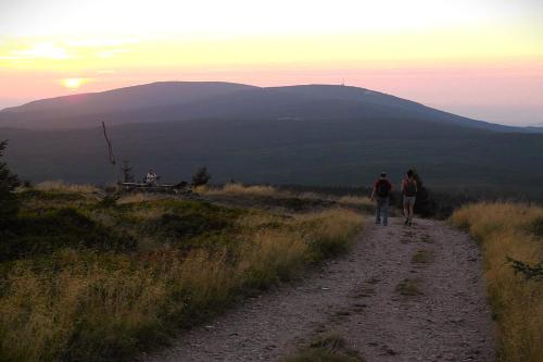 two people walking down a dirt road at sunset at Dom pod Mandragorą in Świeradów-Zdrój