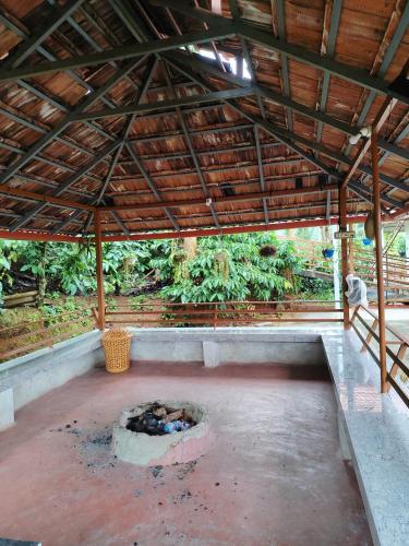 a building with a fire pit in the middle at Shivalaya Homestay, Madikeri in Siddapur