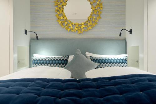 a bedroom with a blue and white bed with a mirror at NEU! Ferienhaus Litj Horsa Hoog - Luxus, Lage, Leichtigkeit mit Wellenrauschen in Wenningstedt Sylt in Wenningstedt