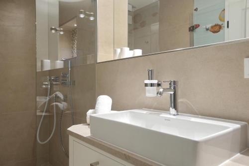 a bathroom with a white sink and a shower at NEU! Ferienhaus Litj Horsa Hoog - Luxus, Lage, Leichtigkeit mit Wellenrauschen in Wenningstedt Sylt in Wenningstedt