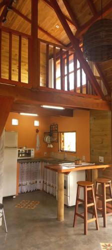 a kitchen with a table and chairs in a room at Chalé Paineira in Córrego do Bom Jesus