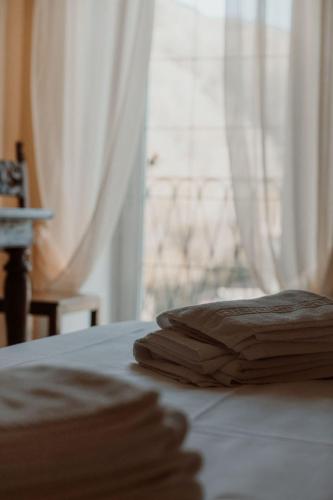 a pair of towels sitting on a bed with a window at Guesthouse Giulietta e Romeo in Cossogno