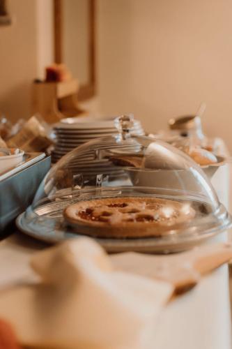 a pizza in a glass dish on a table at Guesthouse Giulietta e Romeo in Cossogno