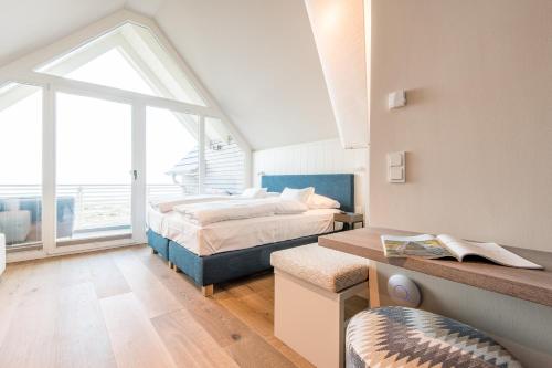 a bedroom with two beds and a large window at Hafen27 Haus No 3 Stranddistel in List