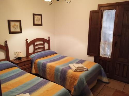 a bedroom with two beds and a window at Casa la Cisterna in Pina de Montolgrao
