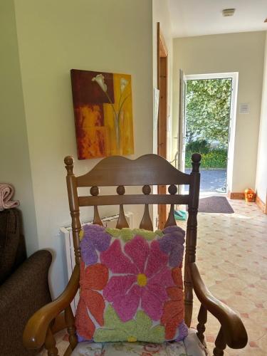 a wooden chair with a pillow in a living room at Woodland Cottage in Galway
