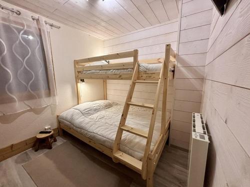 Ce lit superposé se trouve dans un dortoir avec une échelle. dans l'établissement Appartement cosy 3 pièces, avec balcon et piscine, proche des pistes et commodités à La Plagne Tarentaise - FR-1-353-118, à La Plagne Tarentaise
