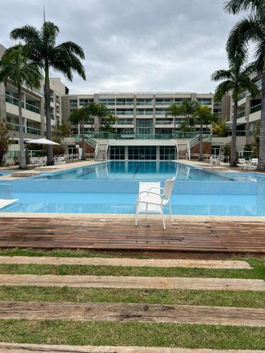 a chair sitting on a boardwalk in front of a swimming pool at Brisas do Lago em Brasília in Brasilia