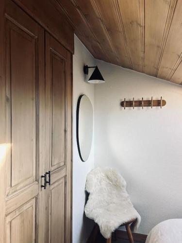 Cette chambre comprend un lit, un miroir et un placard. dans l'établissement Appartement avec vue sur les Dômes du Miage, aux Contamines-Montjoie