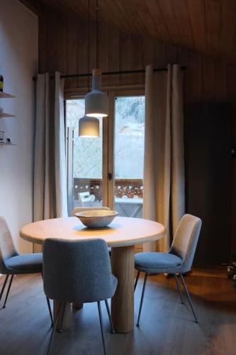 une table de salle à manger avec des chaises et un bol dessus dans l'établissement Appartement avec vue sur les Dômes du Miage, aux Contamines-Montjoie