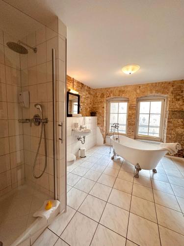 a large bathroom with a tub and a shower at cinderella.kreuzberg in Berlin