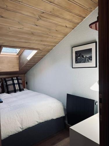 une chambre avec un lit dans une pièce avec une fenêtre dans l'établissement Appartement avec vue sur les Dômes du Miage, aux Contamines-Montjoie