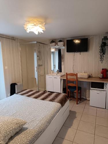 une chambre avec un lit et une cuisine avec une table dans l'établissement La Savouè - Chambre, à Francin