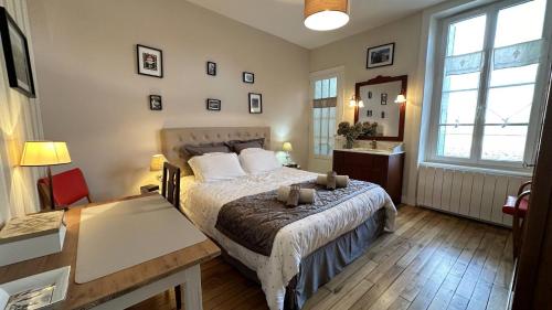 a bedroom with a bed and a desk and windows at Le clos jargot in Limoges