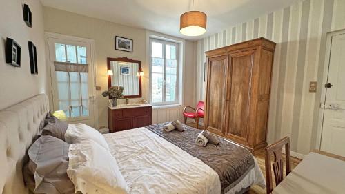 a bedroom with a bed with a dresser and a mirror at Le clos jargot in Limoges