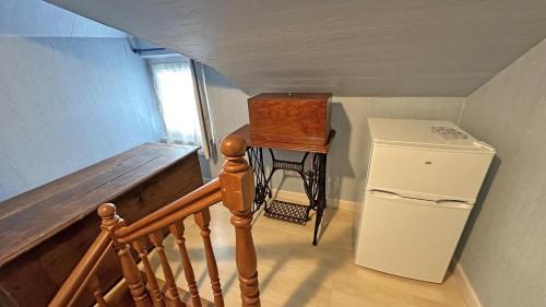 a staircase with a small table and a refrigerator at Le clos jargot in Limoges