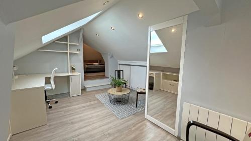 an attic room with a desk and a mirror at Le clos jargot in Limoges