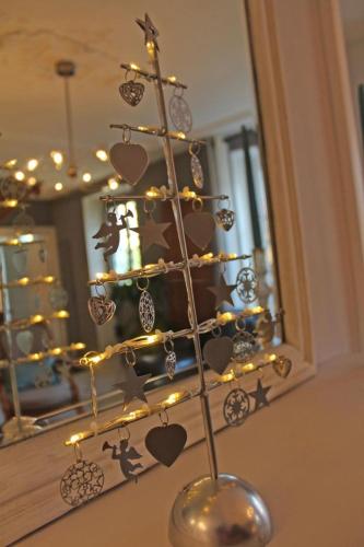 a christmas tree with hearts and lights in front of a mirror at Le clos jargot in Limoges