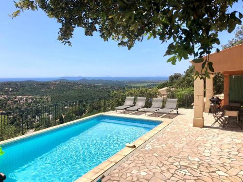 - une piscine avec des chaises et une vue depuis une maison dans l'établissement Villa Camelia pour 8 personnes avec piscine et vue mer au domaine de Valcros à La Londe les Maures, à La Londe-les-Maures