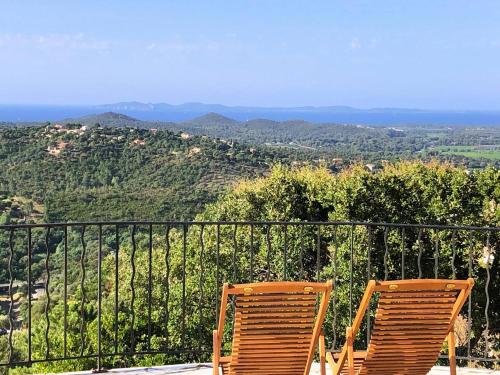 - deux chaises en bois assises sur le balcon dans l'établissement Villa Camelia pour 8 personnes avec piscine et vue mer au domaine de Valcros à La Londe les Maures, à La Londe-les-Maures