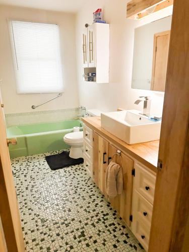 a bathroom with a sink and a tub and a toilet at Maison Chaleureuse in Sherbrooke