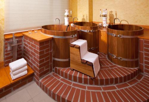 a bathroom with three wooden tubs with a chair in it at Clarion Congress Hotel Olomouc in Olomouc