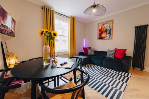 a living room with a table and a couch at 1 Bed Apartments - Central Bath in Bath