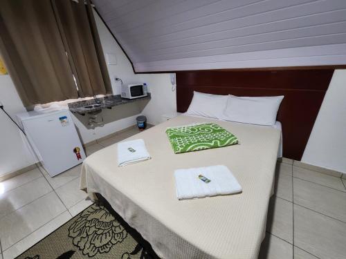 a bedroom with a bed with towels on it at Espaço Chalé Cereja in Cachoeira Paulista