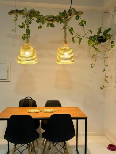a table with four chairs and three lights at Apê tapajós in Santarém